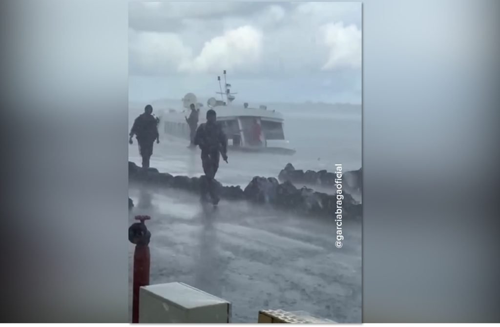 Estudantes da delegação de Barcelos aguardam fiscalização do exército em balsa sob chuva