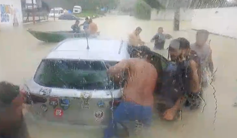 avenida torquato tapajos alagada em manaus com carro preso e canoa circulando durante forte chuva