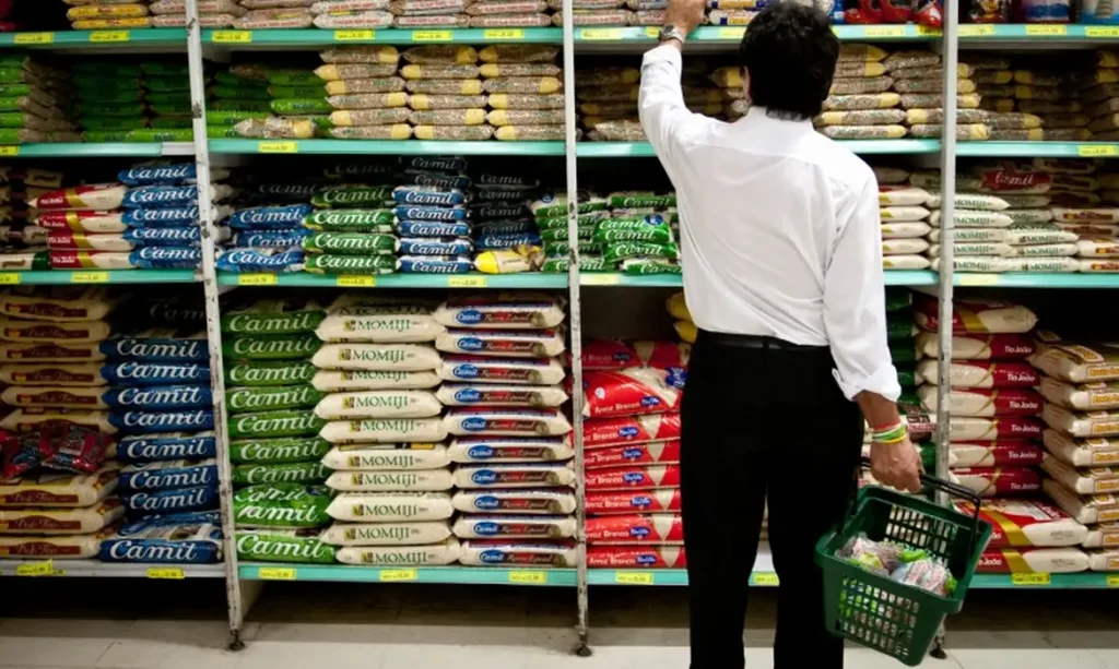 Alimentos variados da cesta básica em um carrinho de compras simbolizando o aumento de preços no brasil