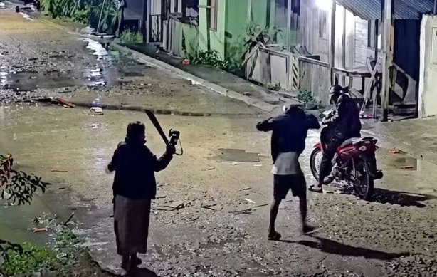 Imagem de vídeo que mostra idosa enfrentando assaltante com sombrinha durante tentativa de roubo
