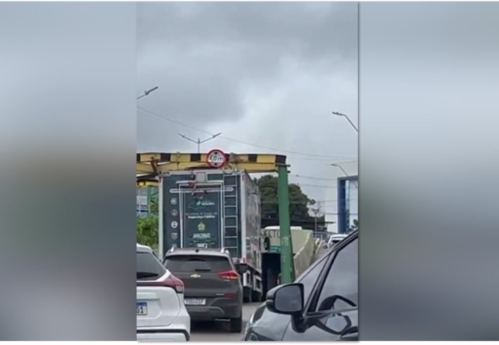 Caminhão preso sob limitador de altura na passagem subterrânea de Manaus