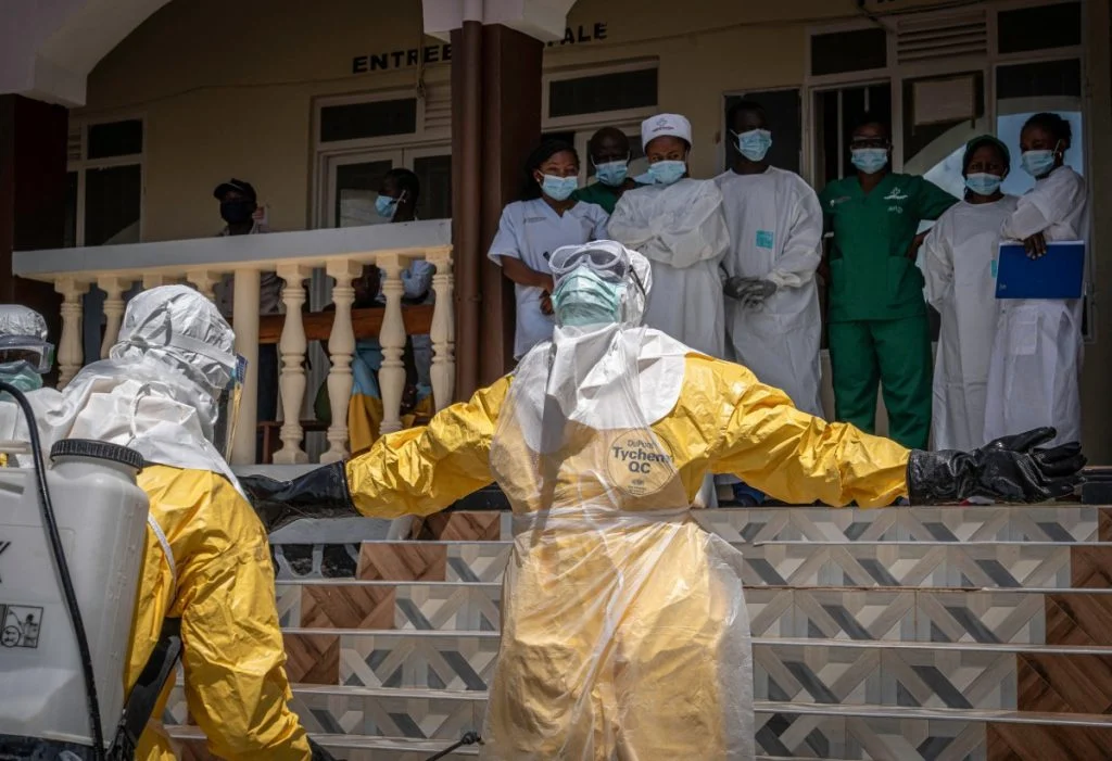 Profissionais de saúde utilizando spray desinfetante após contato com suspeita de ebola na RDC.