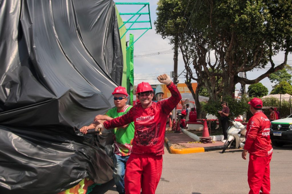 Trabalhadores transportando alegorias dos bois Caprichoso e Garantido para o festival