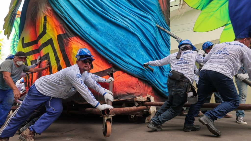 Trabalhadores transportando alegorias dos bois Caprichoso e Garantido para o festival