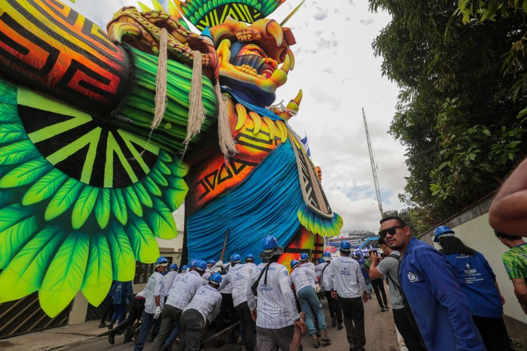 Trabalhadores transportando alegorias dos bois Caprichoso e Garantido para o festival