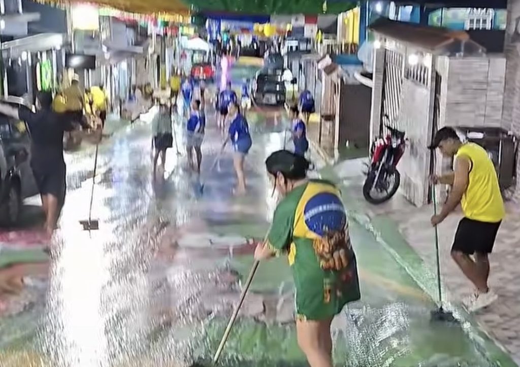 Moradores do bairro Alvorada em Manaus realizam limpeza coletiva da Rua 3 da Copa após jogo do Brasil.